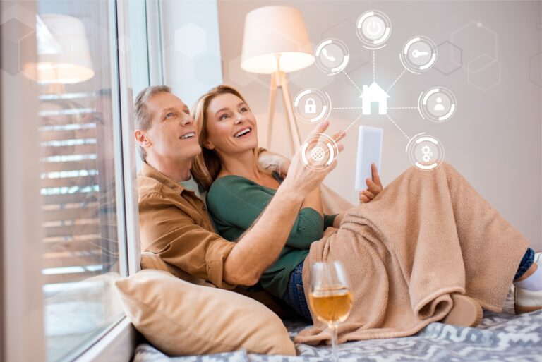 smiling-wife-holding-digital-tablet-while-sitting-on-floor-with-husband-smart-home-concept.jpg