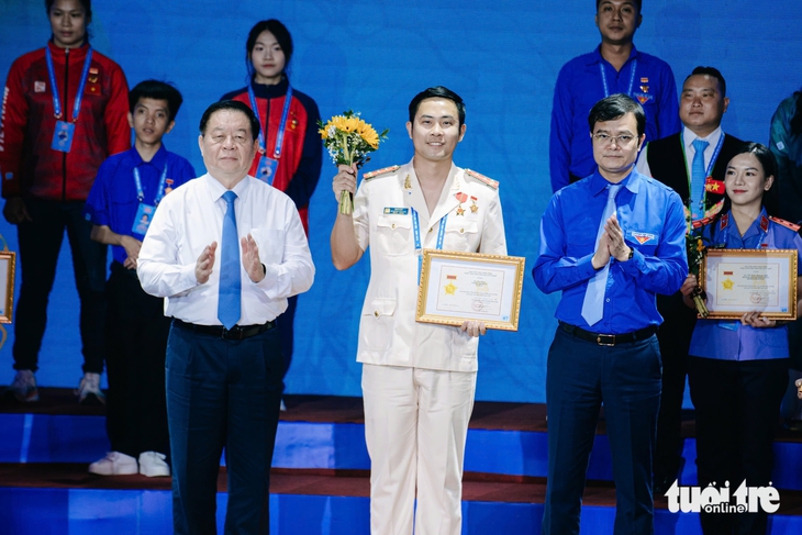 Ủy viên Bộ Chính trị, Bí thư Trung ương Đảng, Trưởng Ban Tuyên giáo và Dân vận Trung ương Nguyễn Trọng Nghĩa (bên trái) và Bí thư thứ nhất Trung ương Đoàn Bùi Quang Huy (bên phải) trao bằng khen cho anh Cao Quý, đại biểu bí thư Đoàn thanh niên T05, Bộ Công an - Ảnh: THANH HIỆP