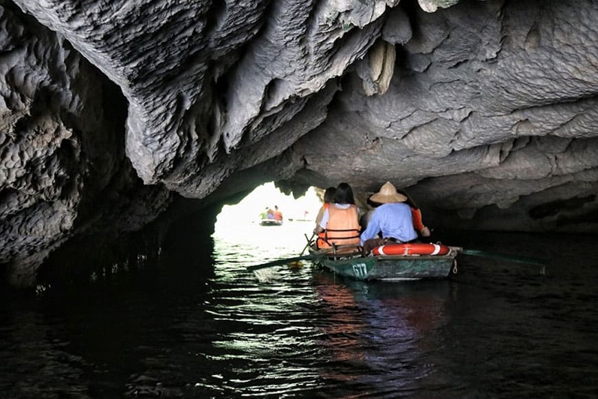 Hành trình khám phá Hang Tối bắt đầu từ bến Trang An, nơi du khách bước lên chiếc thuyền nhỏ do người dân địa phương chèo lái.