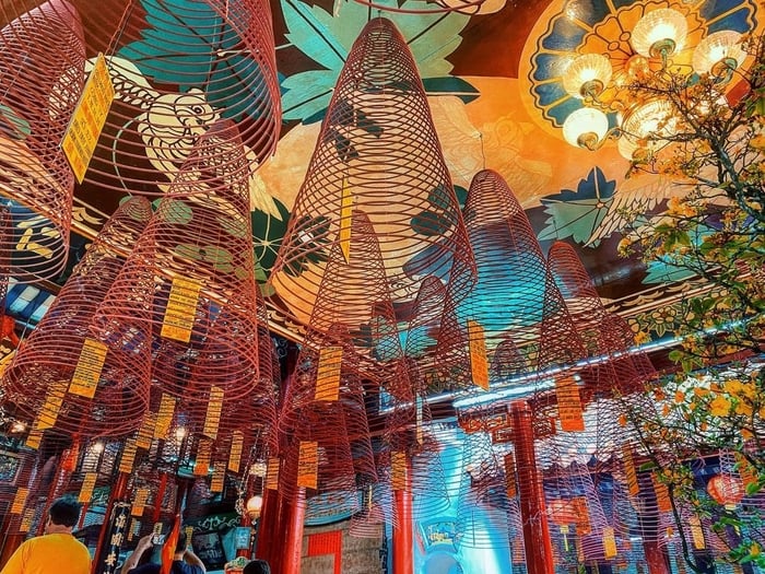 Dòng khói hương uốn lượn, ánh sáng phản chiếu trên các tấm hoành phi dát vàng